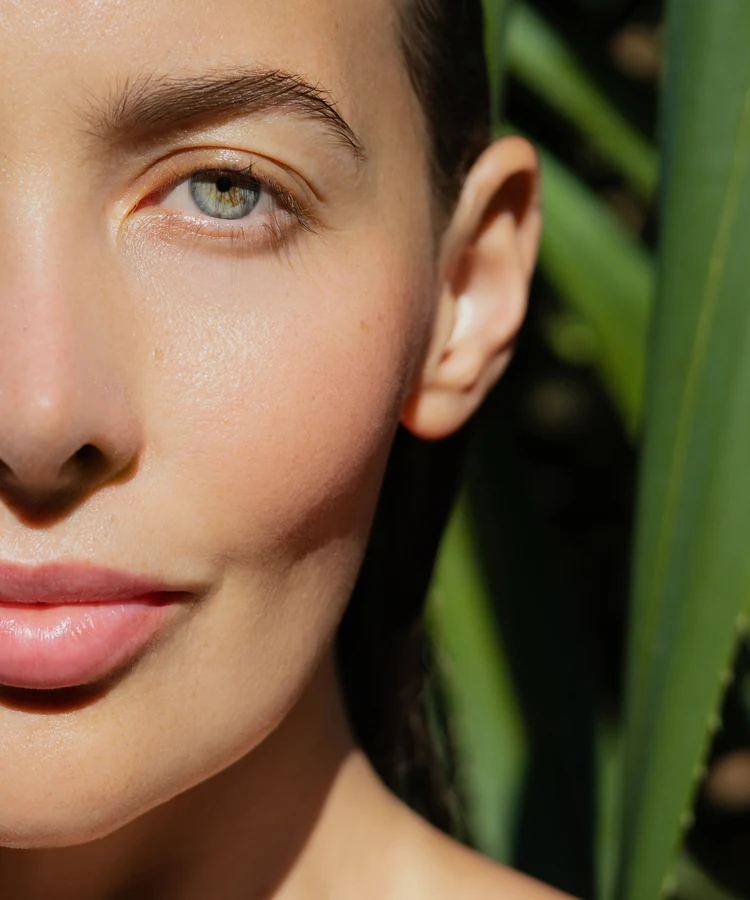 Woman with glowing skin gently touching her face in natural skincare beauty portrait