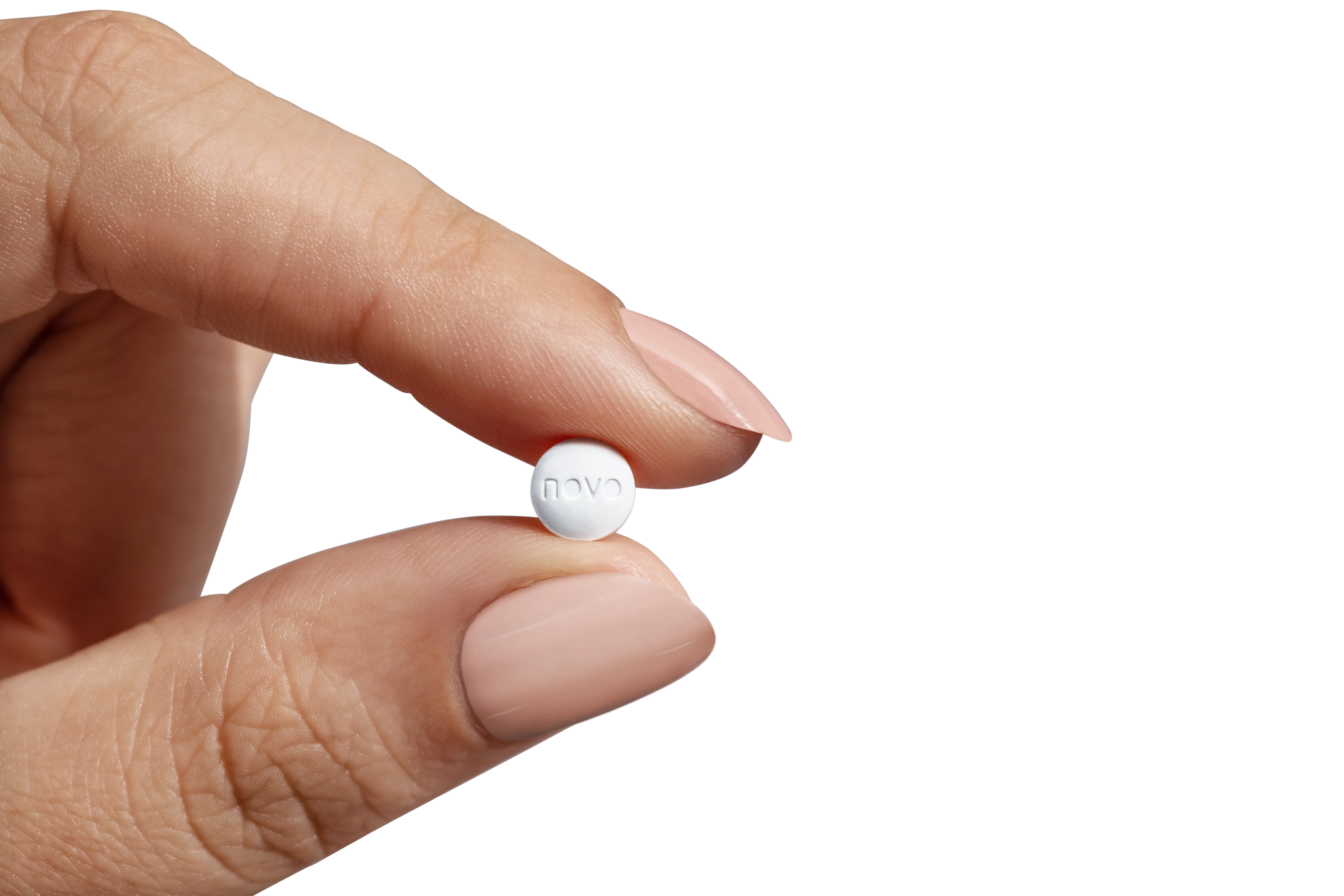 Wegovy® oral semaglutide tablet held between two fingertips
